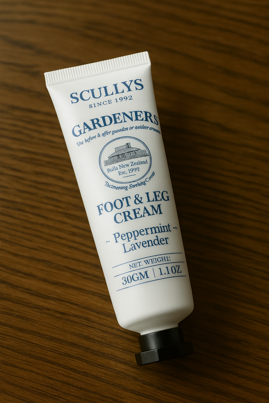 Scullys Foot & Leg Cream – vit tub med blå text mot trötta ben - Liggande på brunt träbord