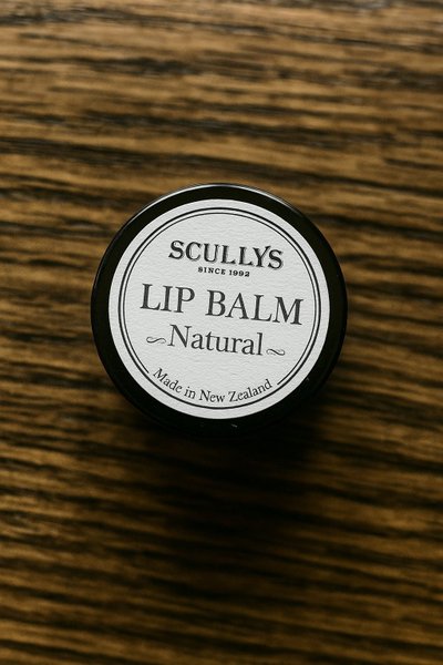 Scullys Natural Lip Balm – 15g burk med vaniljsmak i svart plåtburk - På träbord - uppifrån