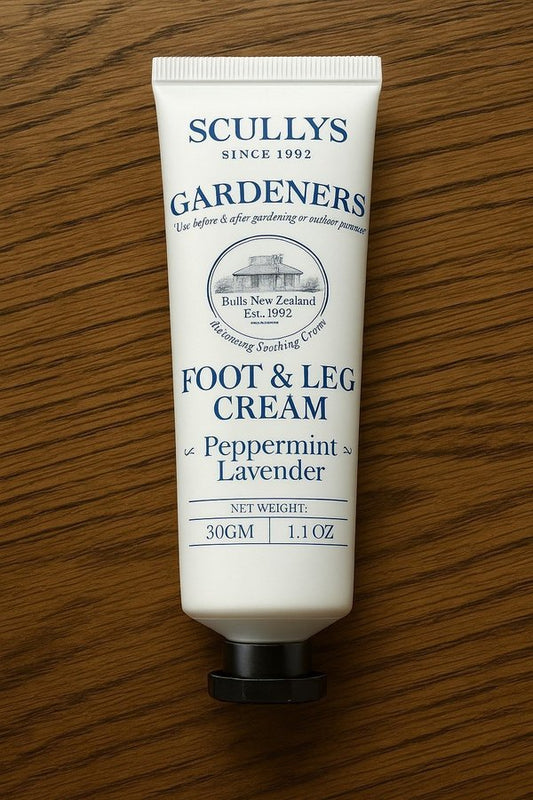 Scullys Foot & Leg Cream – vit tub med blå text mot trötta ben - Liggande på brunt träbord